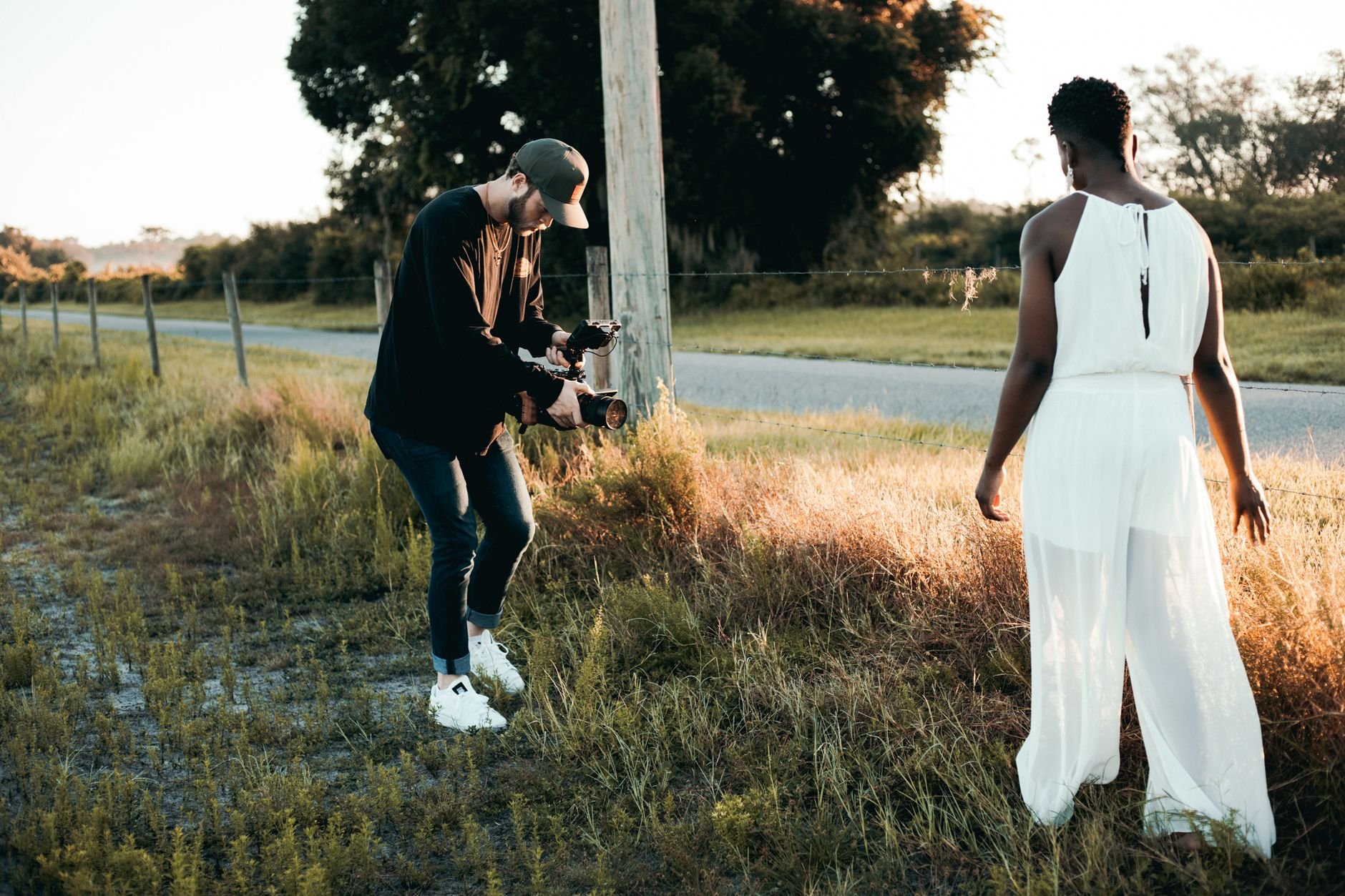 Photographer and model in a serene nature setting during golden hour.